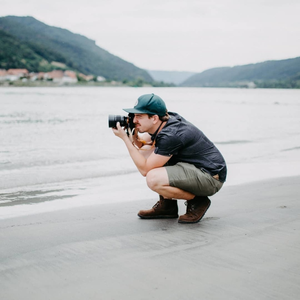 Fotograf an der Donau in den Knien